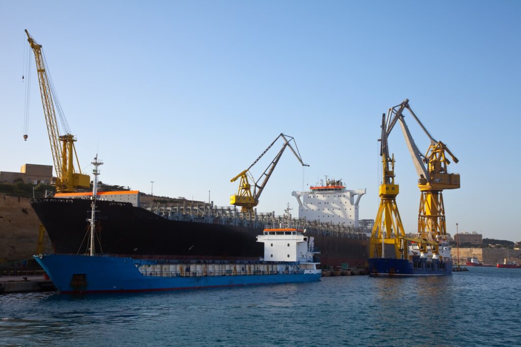 A shipping port with large cargo ships and cranes loading and unloading goods, representing American-made product sourcing, domestic manufacturing, and efficient supply chain logistics in the U.S.